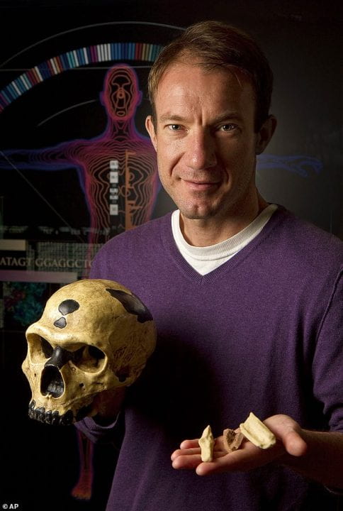 Richard E. (Ed) Green holding a skull and other bones 