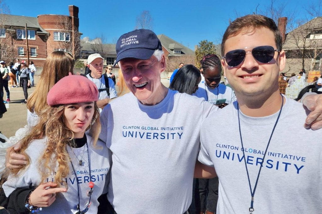 Photo of three people wearing Clinton Global Initiative University t-shirts.