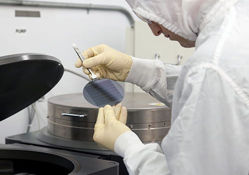 person in a lab coat works on chip fabrication